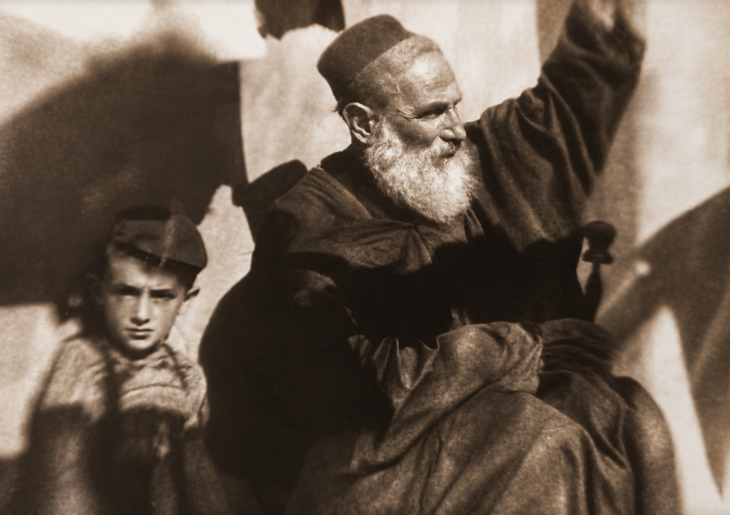An archival family photograph of an elder being carried through a gathering